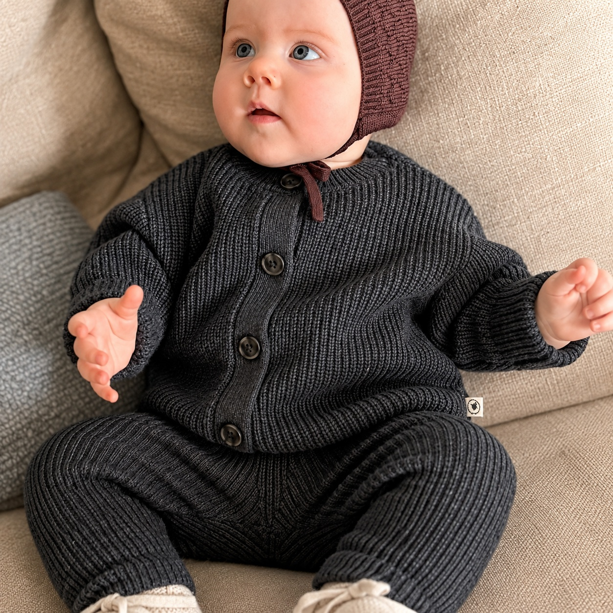 Baby mit Babymütze Ela in bordeaux und Cardigan Ferdi